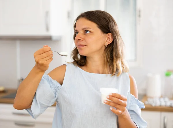 Positive Young Woman Eating Tasty Yogurt Kitchen Interior — 图库照片