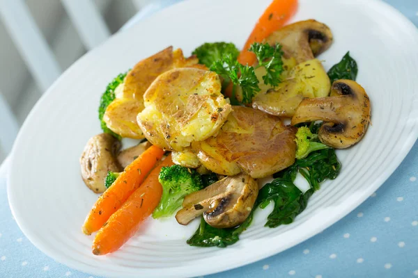 Dish of Australian cuisine - Crash Hot Potatoes, served with fried mushrooms and vegetables