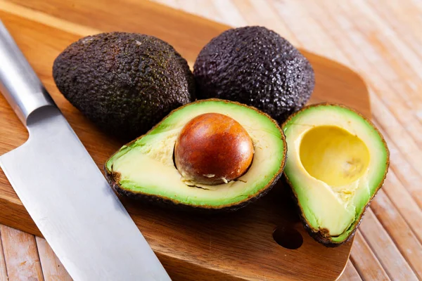 Rijp Sappige Avocado Liggend Een Snijplank Een Houten Oppervlak Ingrediënten — Stockfoto