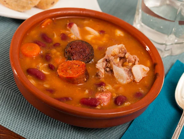 Traditional Asturian rich beans stew with pork shoulder, morcilla and chorizo Fabada served in clay bowl