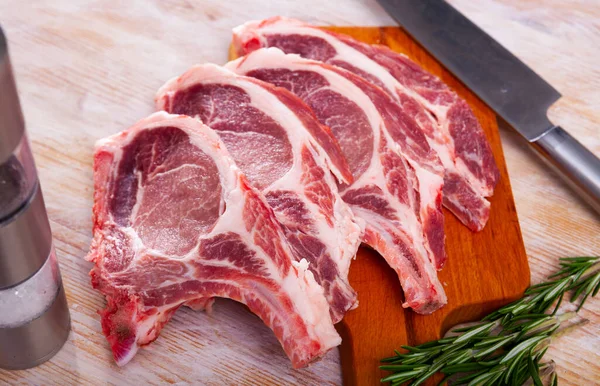 Raw Juicy Pork Loins Bone Ready Cooking Rosemary Wooden Table — Zdjęcie stockowe