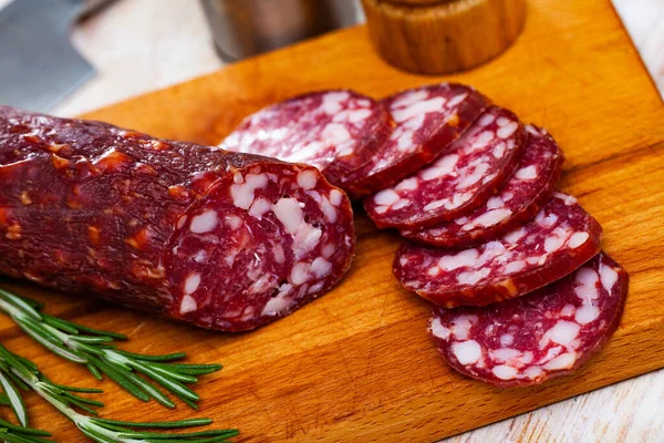 Tasty dried semi-dry sausage Braunschweig with rosemary. High quality photo