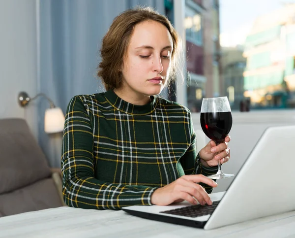 Attractive Young Woman Using Laptop Drinking Wine Home — Zdjęcie stockowe