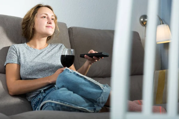 Positive Girl Sitting Sofa Home Watching Holding Glass Red Wine — Zdjęcie stockowe