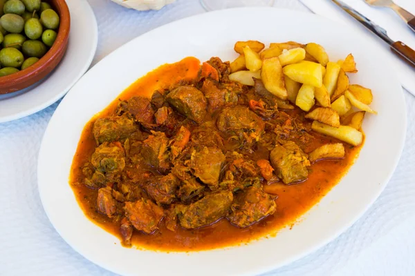 Juicy baked chopped pork cheeks served with potato and vegetables