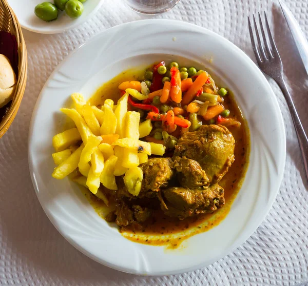 Appetizing baked pork cheeks served with potato and vegetables on plate