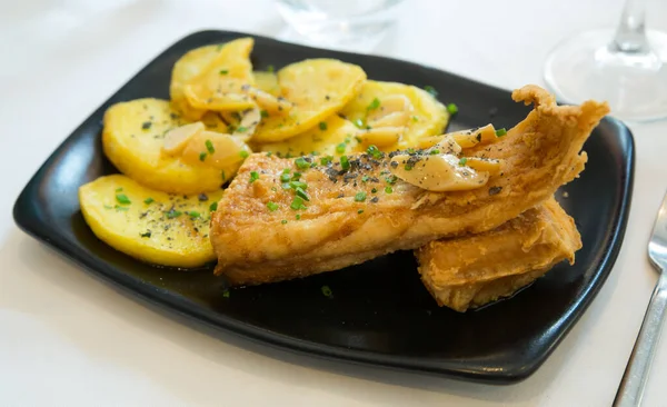 Basque Country cuisine. Fried skate wings a la Santurce with baked potatoes ..