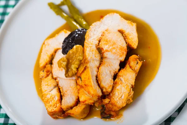 Delicious poultry dish - baked turkey breast with prunes, walnut and spicy sauce on plate