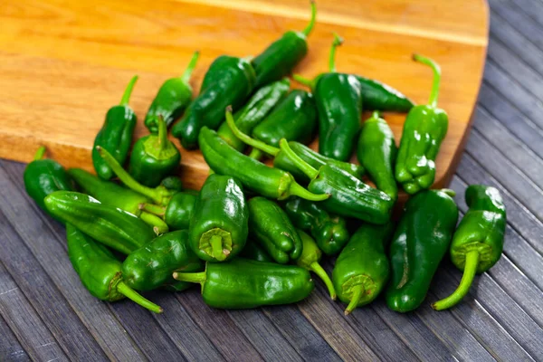 Lots Green Peppers Wooden Cutting Board — Stockfoto