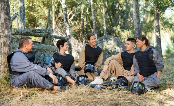 Positive Paintball Players Sitting Ground Break Rounds Smiling Chatting Each — Fotografia de Stock