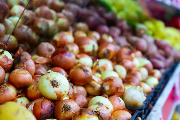 Fresh onions for sale on counter of farmer market. Agricultural products