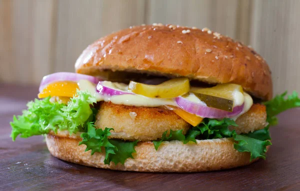 Delicious tasty burger with chicken cutlet, vegetables and cheese at plate