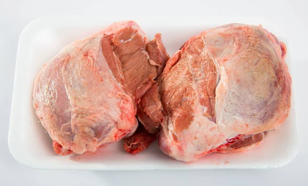 Close up of raw pigs cheeks on white table, no people