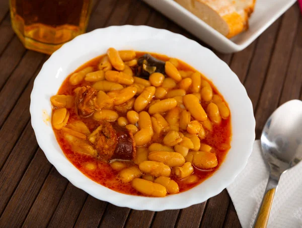 传统的阿斯图里亚斯丰富的豆类炖牛肉法贝达与猪肉肩 莫希利亚和Chorizo在白盘 — 图库照片