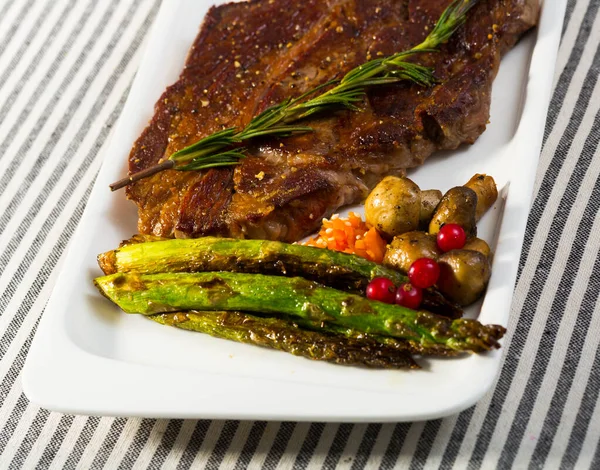Prepared steak entrecote of beef with mushroom and asparagus at plate