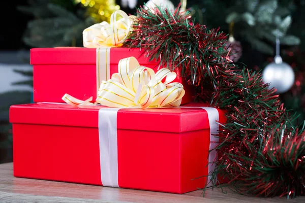 Twee Rode Geschenkdozen Houten Tafel Tegen Achtergrond Van Gekleed Kerstboom — Stockfoto