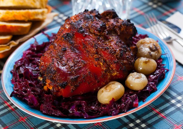 Juicy baked in beer chopped pork knuckle served with braised red cabbage.