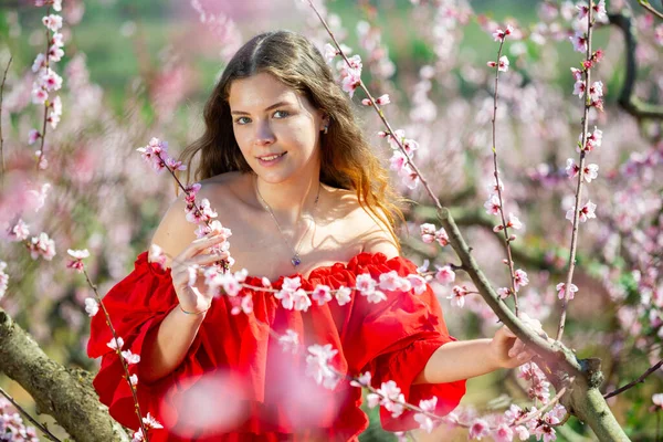 Glada Flicka Poserar Röd Klänning Vår Blommande Garde — Stockfoto