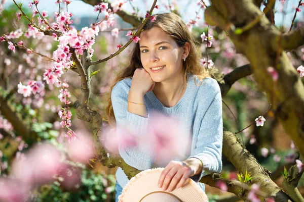 Жінка Джинсах Синій Светр Чарівною Посмішкою Позує Квітучому Парку Насолоджуючись — стокове фото