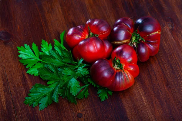 Close-up of fresh brown tomatoes on wooden surface in home kitchen