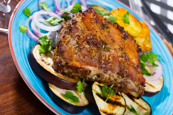 有烤茄子和洋葱的多汁烤猪肉包放在盘子里 — 图库照片