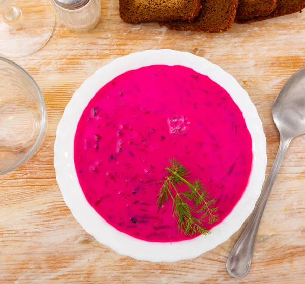 Traditional Belarusian cold vegetable soup Holodnik with beetroot and egg on chekered tablecloth