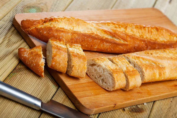 法国长而薄的面包 木面上有切碎的薄片 新鲜烘焙食品 — 图库照片