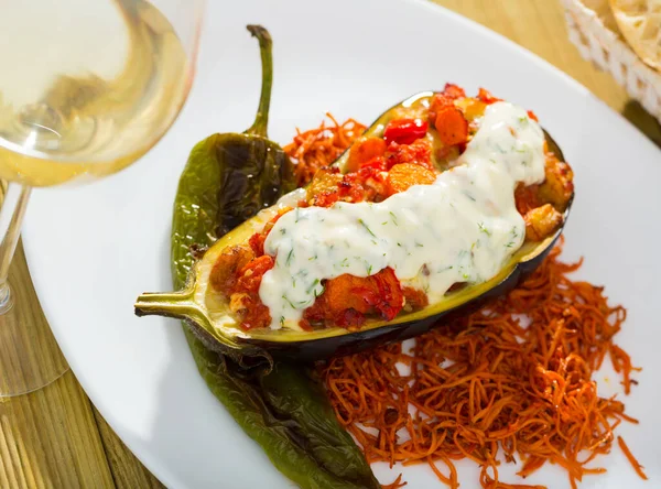 Delicious baked eggplant stuffed with vegetable mix served with tzatziki sauce..