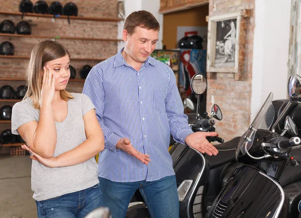 女と男は現代的なバイクを選択していると女は驚いています選択彼女のボーイフレンドでザ — ストック写真
