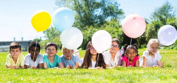 Portret Szczęśliwych Dzieci Balonami Pozujących Trawie Parku Słoneczny Dzień — Zdjęcie stockowe