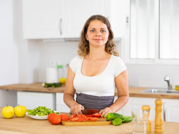 若い笑顔の女性は 家庭用キッチンで野菜を切り刻む ビーガン料理を準備 — ストック写真