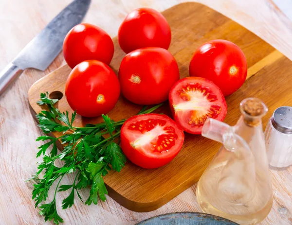 在厨房桌子上用欧芹枝条煎熟多汁的西红柿 准备食物概念 — 图库照片