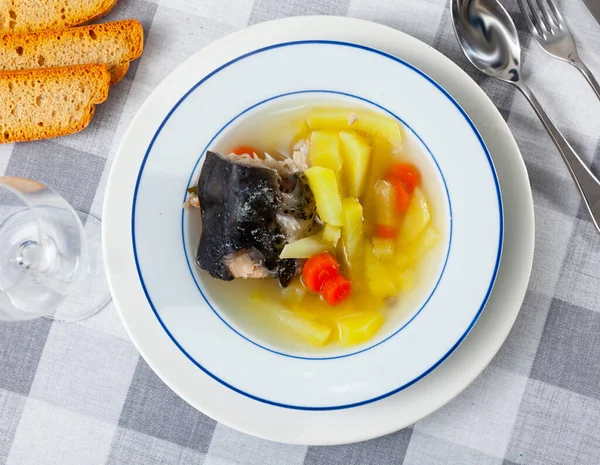 Fish soup with salmon bones and head, potato and carrot