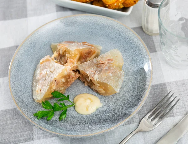 Traditional russian meat aspic dish kholodets on plate with mustard and parsley.