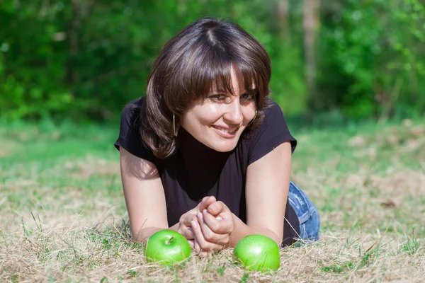 Pretty young girl and apples on hay — Stock Photo, Image