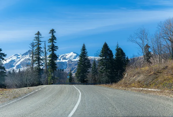 Estrada para alturas nevadas nas montanhas — Fotografia de Stock