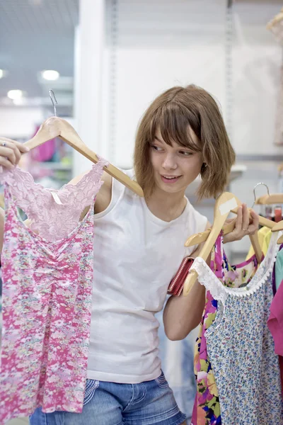 A menina na loja experimenta roupas — Fotografia de Stock