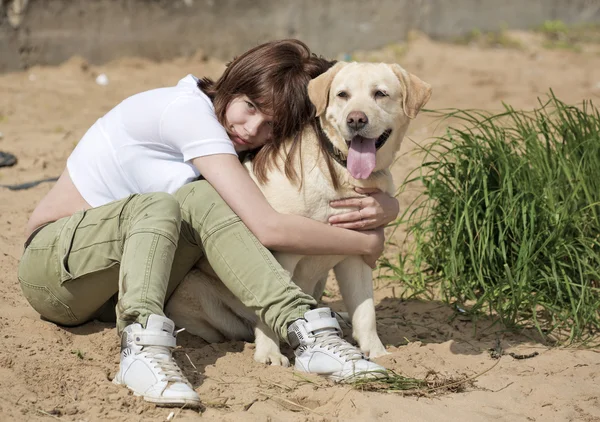 Genç bir kadın köpek kucaklar — Stok fotoğraf