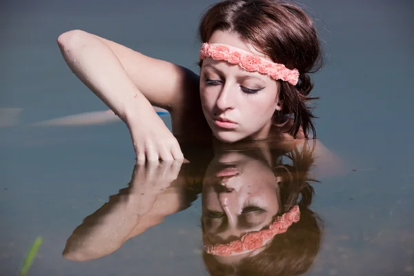 The girl in water looks at reflexion — Stock Photo, Image