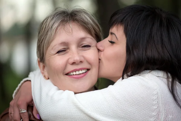 La ragazza abbraccia e bacia la donna — Foto Stock