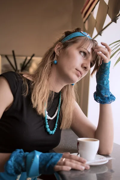 La jeune femme est assise avec une tasse à une fenêtre — Photo