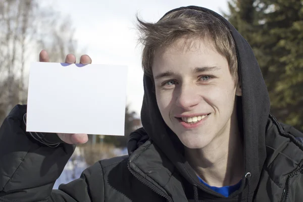Genç adam saf bir kağıdın tutar — Stok fotoğraf