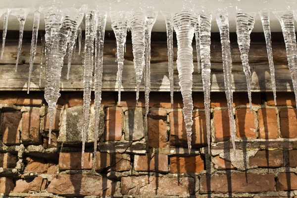 Buz buz sarkıtları duvara karşı — Stok fotoğraf