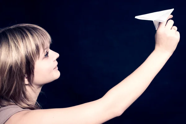 Jolie femme tenant un avion en papier et souriant — Photo