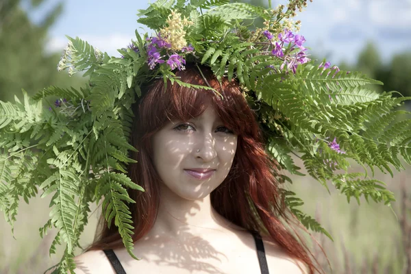 頭の上の花の花輪を持つ美しい少女のクローズ アップの肖像画 — ストック写真