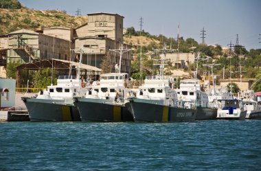 military ship and yacht in bay