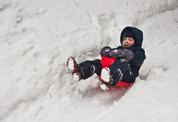 Little boy riding on a sled — Stock Photo, Image