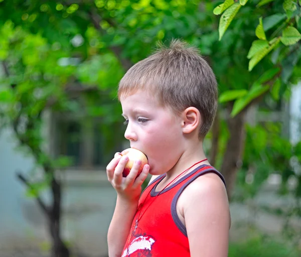 Jongen eet een appel — Stockfoto