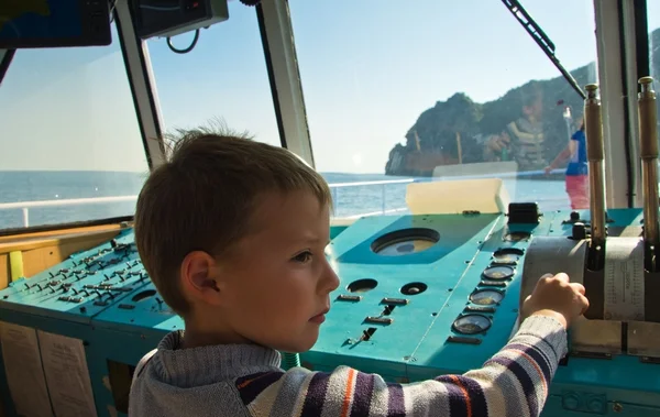 Ragazzo al timone di una nave — Foto Stock