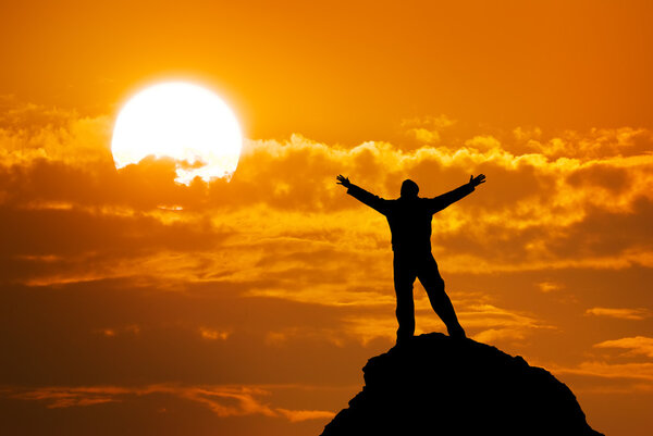 Man on peak of mountain.